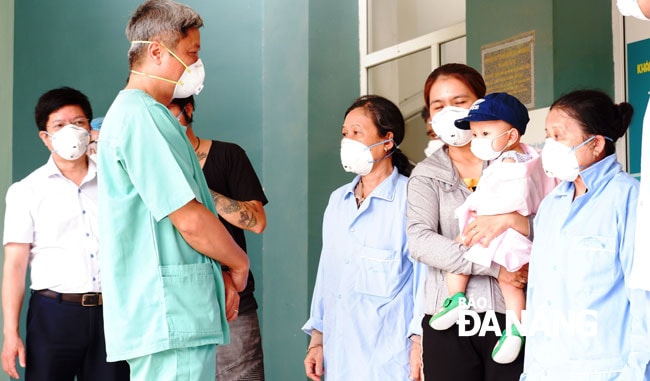 Thử trưởng Bộ Y tế Nguyễn Trường Sơn thăm hỏi, dặn dò bệnh nhân 8 tháng tuổi trước khi xuất viện. Ảnh: PHAN CHUNG