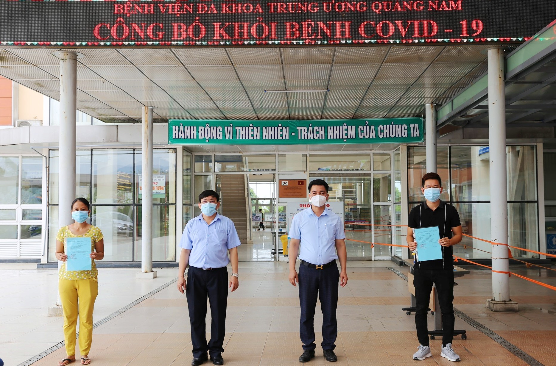 Lãnh đạo Bệnh viện Đa khoa Trung ương Quảng Nam trao giấy xác nhận hoàn thành điều trị Covid-19 và thực hiện các thủ tục xuất viện cho hai bệnh nhân 716, 719. Ảnh: LÊ PHƯƠNG THẢO