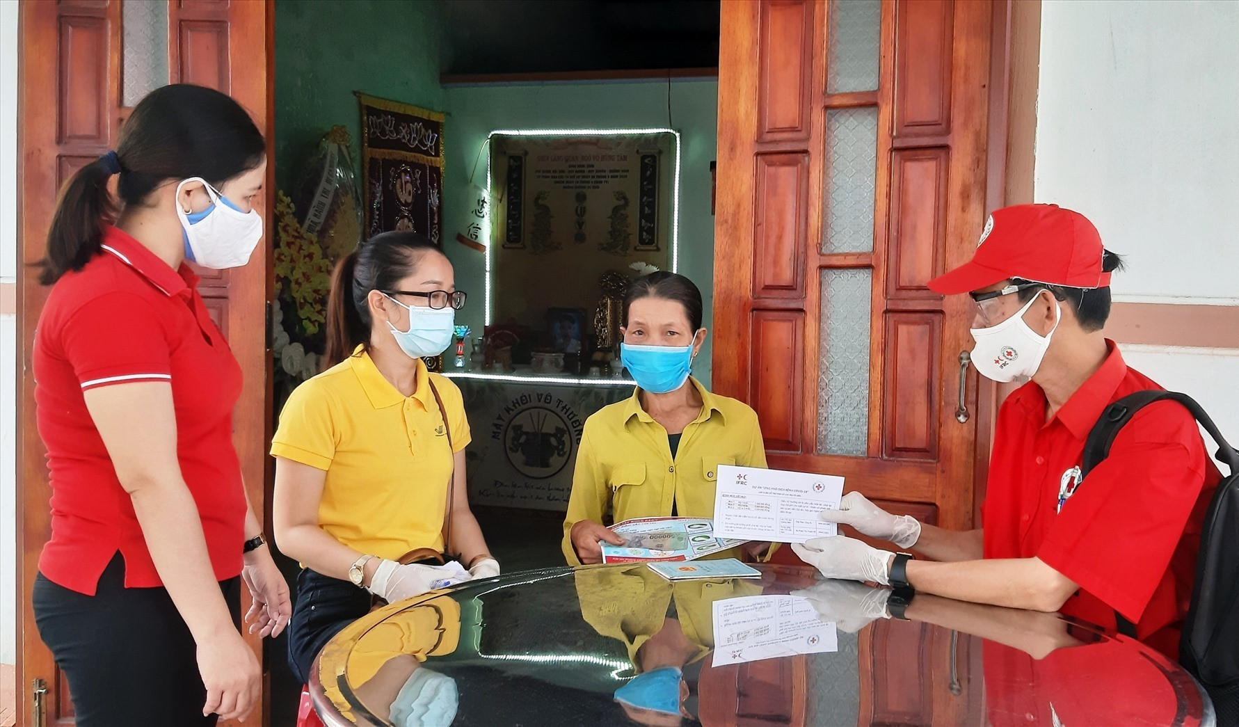 Đại diện lãnh đạo Hội Chữ thập đỏ tỉnh đến tận nhà trao tiền hỗ trợ người dân xã Duy Nghĩa vào sáng nay 14.8. Ảnh: T.P
