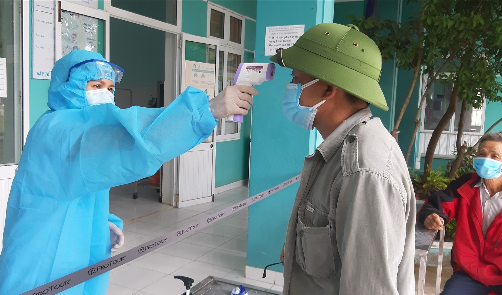 Cán bộ y tế đo thân nhiệt cho người dân xã Duy Trung nhằm sớm phát hiện những trường hợp nghi ngờ nhiễm dịch. Ảnh: T.P