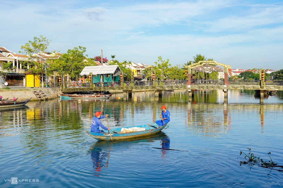 Trash collectors on the Hoai river near An Hoi bridge, where there is a post to control the entry into and exist out of the residents in the areas of Covid-19 confirmed cases in Hoi An.