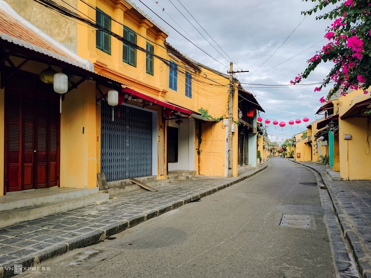 Deserted Hoi An with yellow walls and pink Bougainvillea flowers