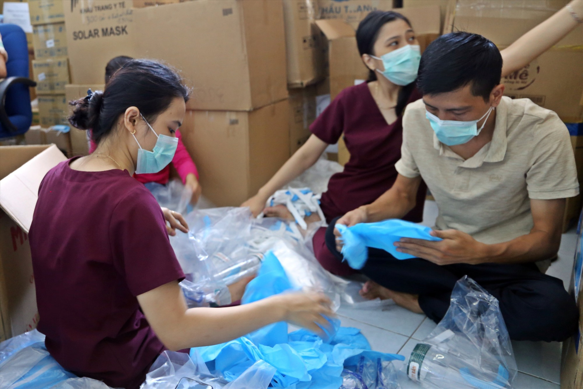 Các y bác sĩ, nhân viên của Bệnh viện Đa khoa Trung ương Quảng Nam tranh thủ buổi tối để chuẩn bị các trang bị bảo hộ cho đội ngũ điều trị bệnh nhân Covid-19. Ảnh: THẢO ĐẠO