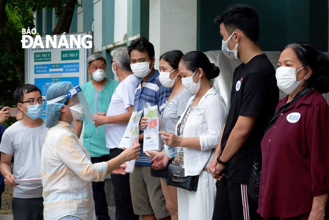 Giám đốc Sở Y tế Ngô Thị Kim Yến trao giấy xuất viện cho các bệnh nhân đồng thời khuyến cáo thực hiện nghiêm các biện pháp cách ly, theo dõi 14 ngày tại nhà. Ảnh: PHAN CHUNG