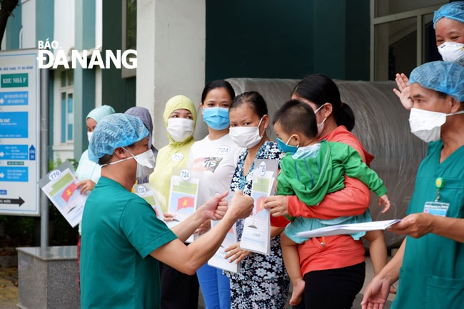 Bác sĩ Nguyễn Đại Vĩnh, Giám đốc Trung tâm Y tế huyện Hòa Vang trao giấy ra viện và động viên các bệnh nhân. Ảnh: PHAN CHUNG