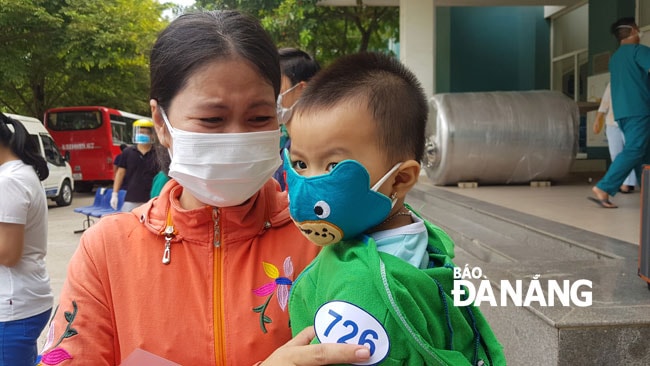 Niềm vui của mẹ bệnh nhân 726 (18 tháng tuổi) sau khi con được điều trị khỏi Covid-19. Ảnh: PHAN CHUNG