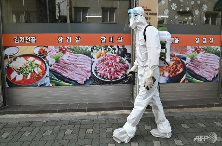 Phun thuốc diệt khuẩn để ngăn chặn vi rút corona lây lan rộng tại Hàn Quốc. Ảnh: AFP