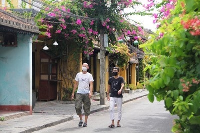 Foreign visitors in Hoi An wear face masks to prevent the spread of COVID-19. Photo: VOV