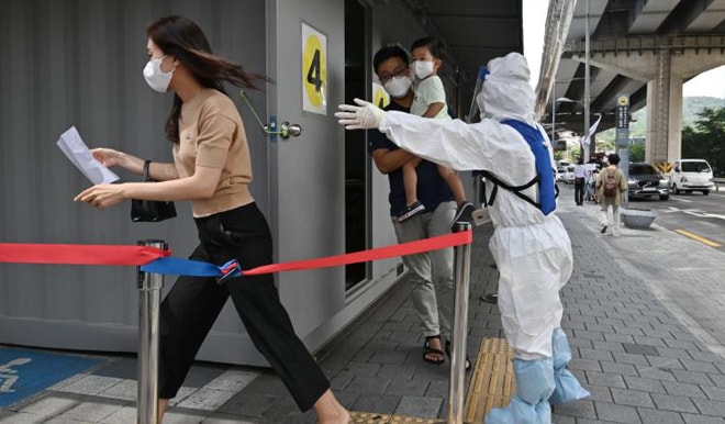 Nhân viên y tế hướng dẫn du khách làm xét nghiệm tại nhà ga ở thủ đô Seoul, Hàn Quốc. Ảnh: CNN