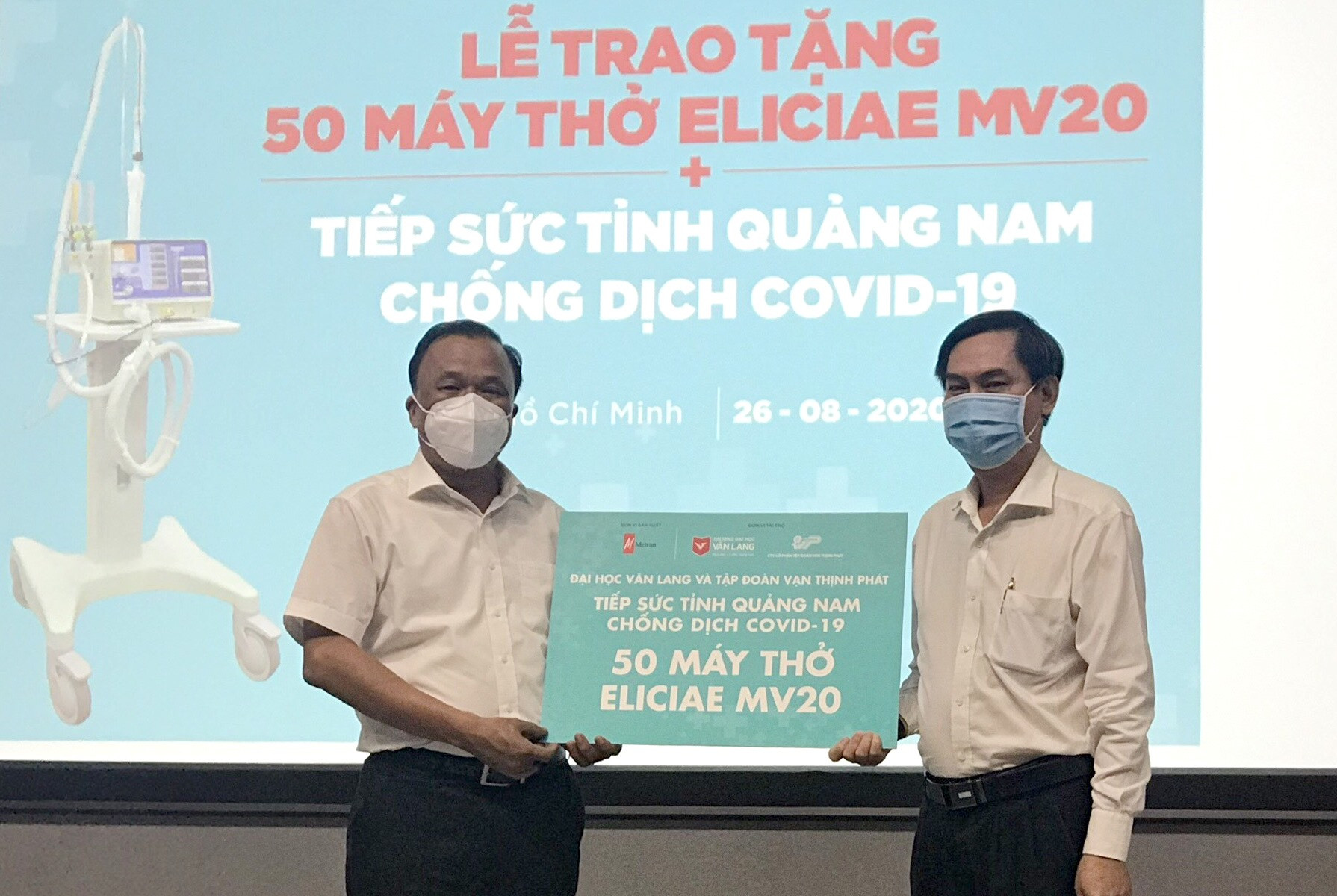 Ông Mai Văn Mười - Phó Giám đốc Sở Y tế (bên trái) tiếp nhận máy thở từ lãnh đạo Trường Đại học Văn Lang. Ảnh: THÙY AN