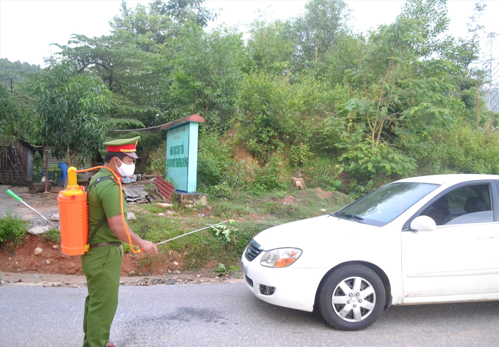 Cán bộ Công an Đông Giang phun khử trùng phương tiện qua chốt chặn kiểm soát dịch Covid-19 trên đường Hồ Chí Minh. Ảnh: C.T