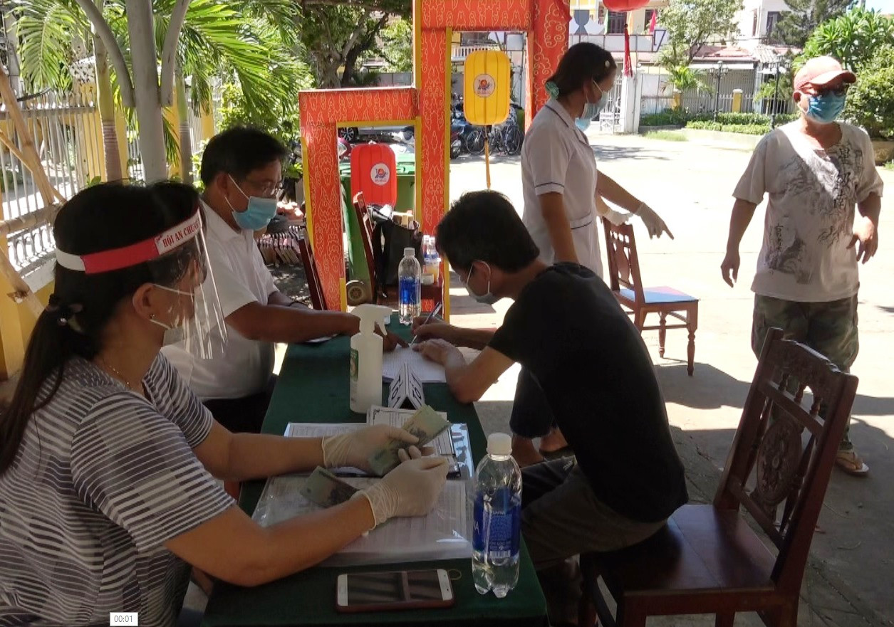 Người lao động tại phường Cẩm Phô nhận tiền hỗ trợ theo Nghị quyết 42 của Chính phủ. Ảnh: PHÚ TOÀN