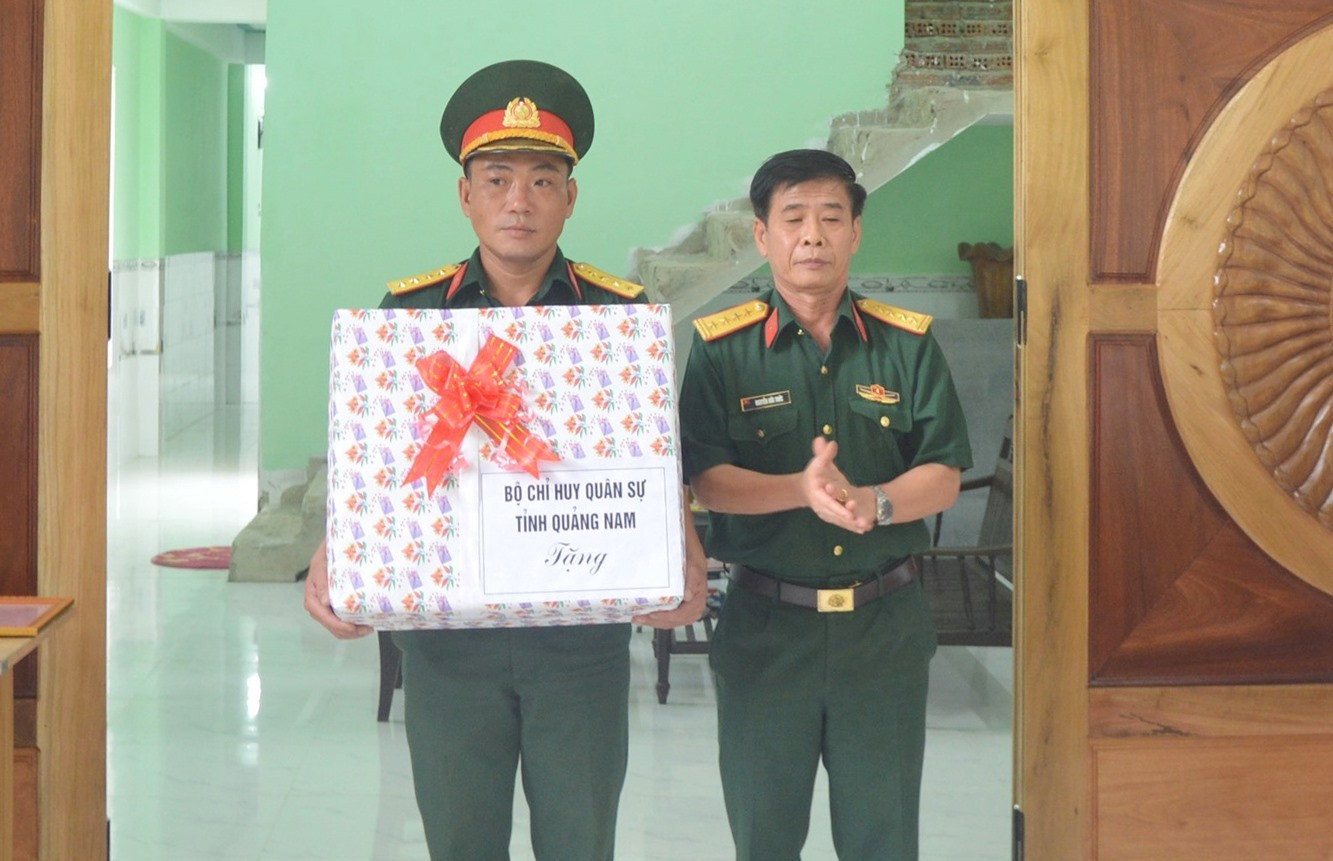 Đại tá Nguyễn Hữu Thức, Phó Chính ủy Bộ CHQS tỉnh tặng quà cho chúc mừng gia đình Đại úy Ngô Sỹ Đức.Ảnh: T.P