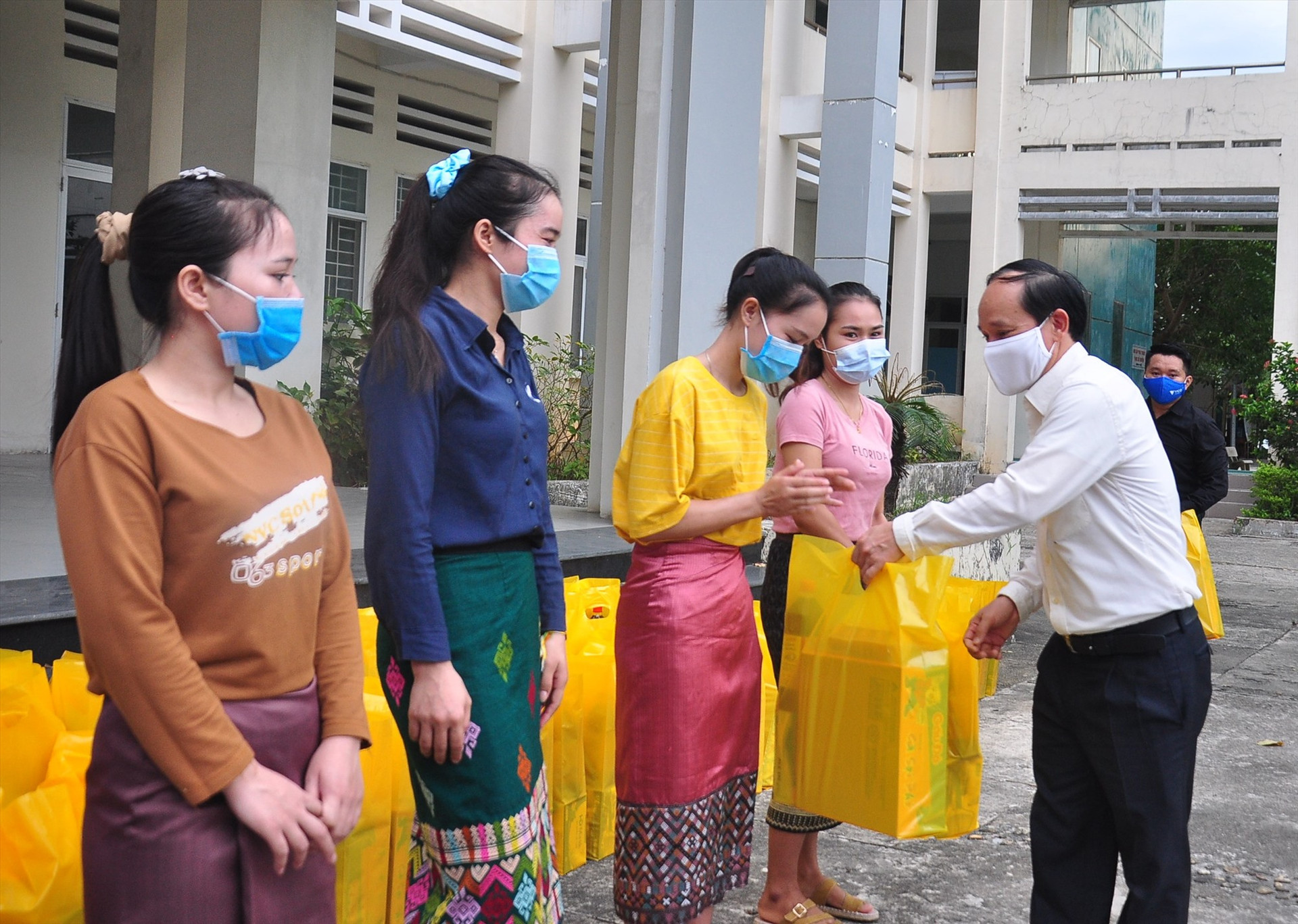 Ông Phạm Quốc Hùng - Phó Chủ tịch Hiệp hội Doanh nghiệp Quảng Nam tặng quà cho các sinh viên Lào. Ảnh: VINH ANH