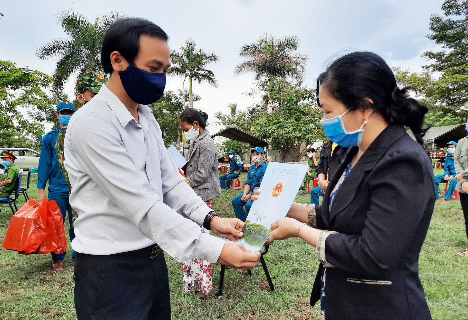 Phó Chủ tịch UBND TP.Tam Kỳ Nguyễn Hồng Lai trao giấy xác nhận hoàn thành cách ly y tế tập trung cho 19 công dân. Ảnh: Đ. ĐẠO