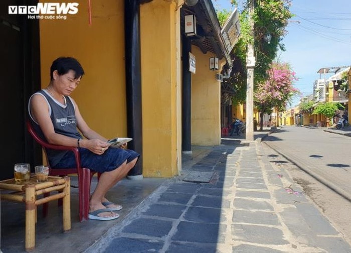 A man sitting in front of a quiet street. Photo: vtcnews