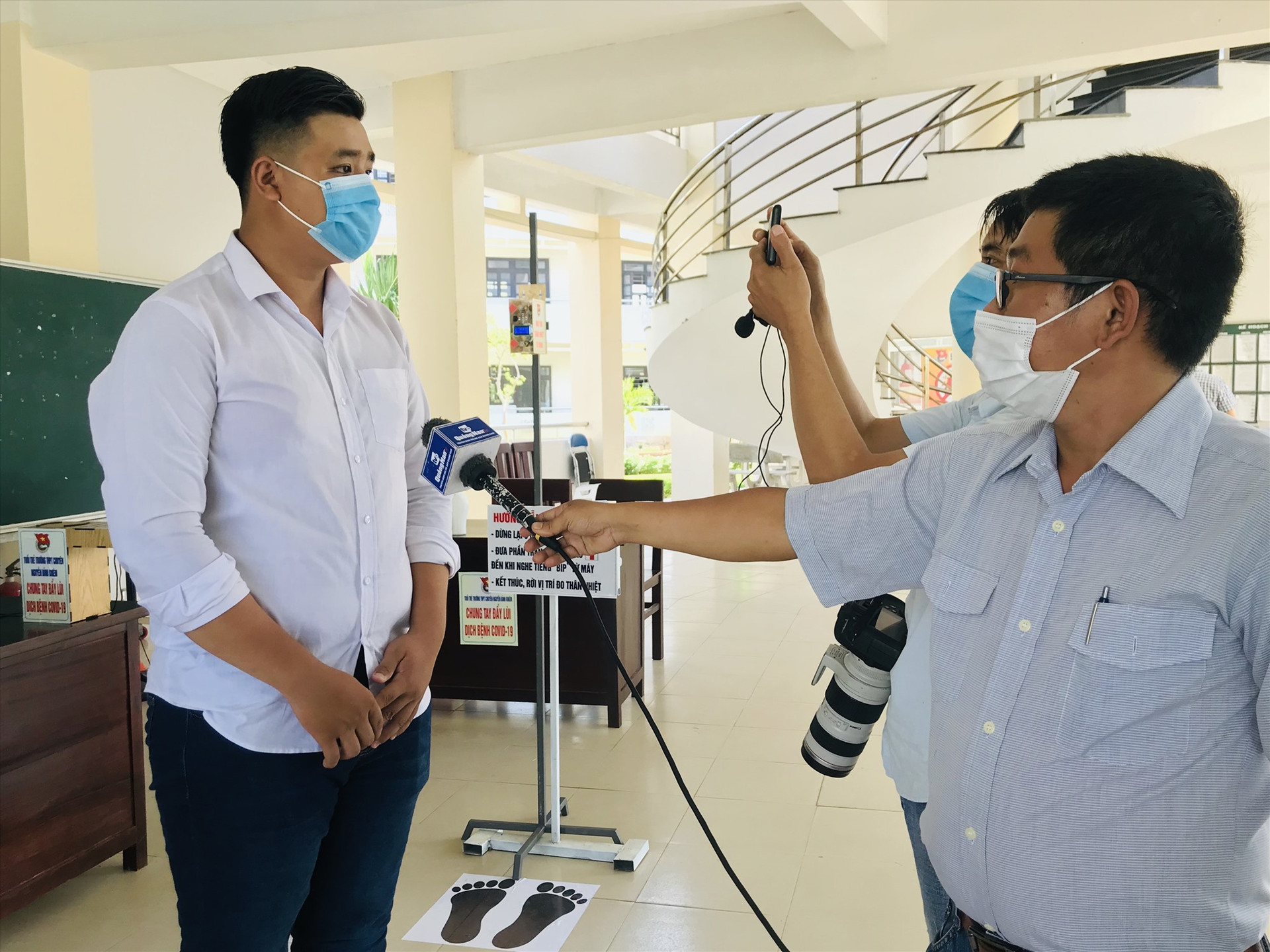 Nguyễn Đặng Quốc Hưng (Trường THPT chuyên Nguyễn Bỉnh Khiêm) trả lời phỏng vấn về máy máy đo thân nhiệt tự động do em sáng chế. Ảnh: C.N