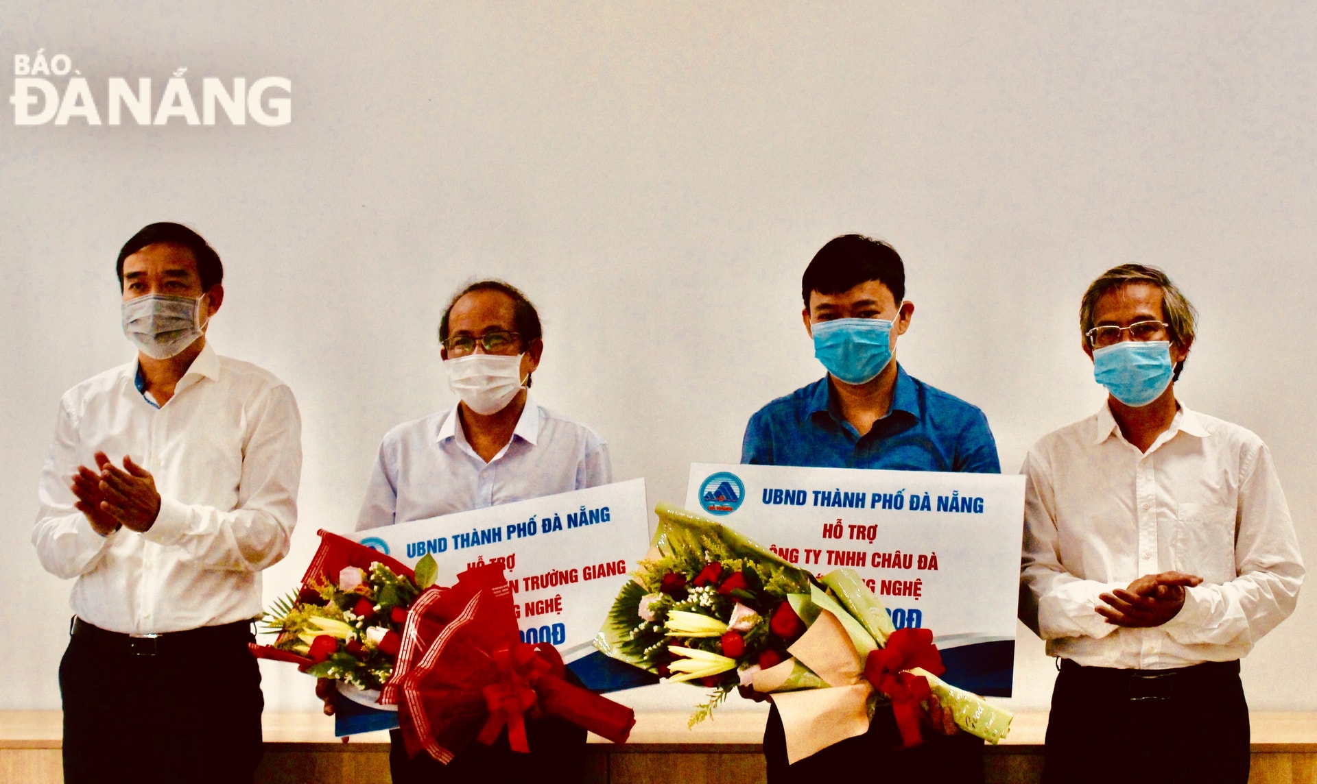 Phó Chủ tịch UBND thành phố Lê Trung Chinh (ngoài cùng bên trái) trao hỗ trợ đổi mới công nghệ cho 2 doanh nghiệp. Ảnh: PHONG LAN