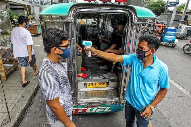 Kiểm tra thân nhiệt nhằm ngăn chặn sự lây lan của dịch Covid-19 tại Manila, Philippines. Ảnh: THX-TTXVN