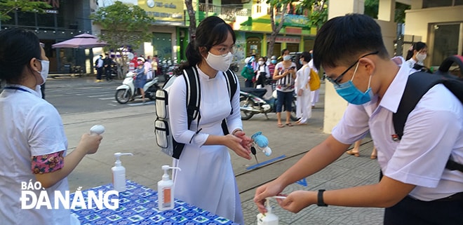 Học sinh THPT sát khuẩn, đeo khẩu trang trước khi vào lớp học. (Trong ảnh: Học sinh Trường THPT Trần Phú sát khuẩn phòng, chống Covid-19).