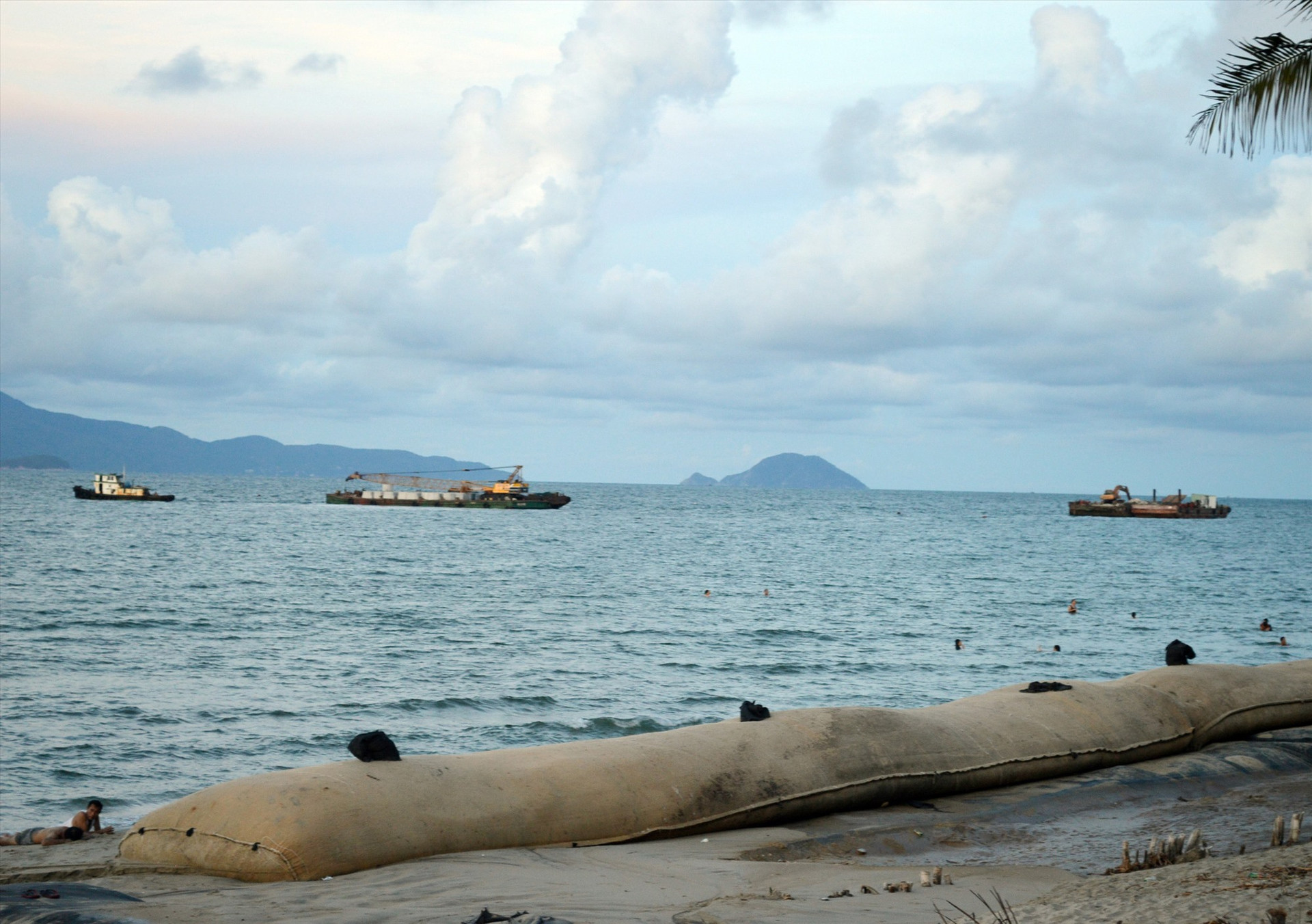 Các xà lan thi công tuyến đê ngầm chắn sóng từ xa nhằm bảo vệ bờ biển Cửa Đại. Ảnh: V.Lộc