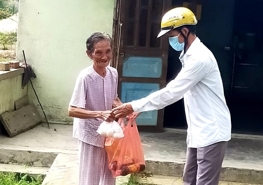 Thầy Nguyễn Tấn Sinh trao quà cho những gia đình neo đơn, có hoàn cảnh khó khăn bị ảnh hưởng bởi dịch Covid-19. Ảnh: T.P