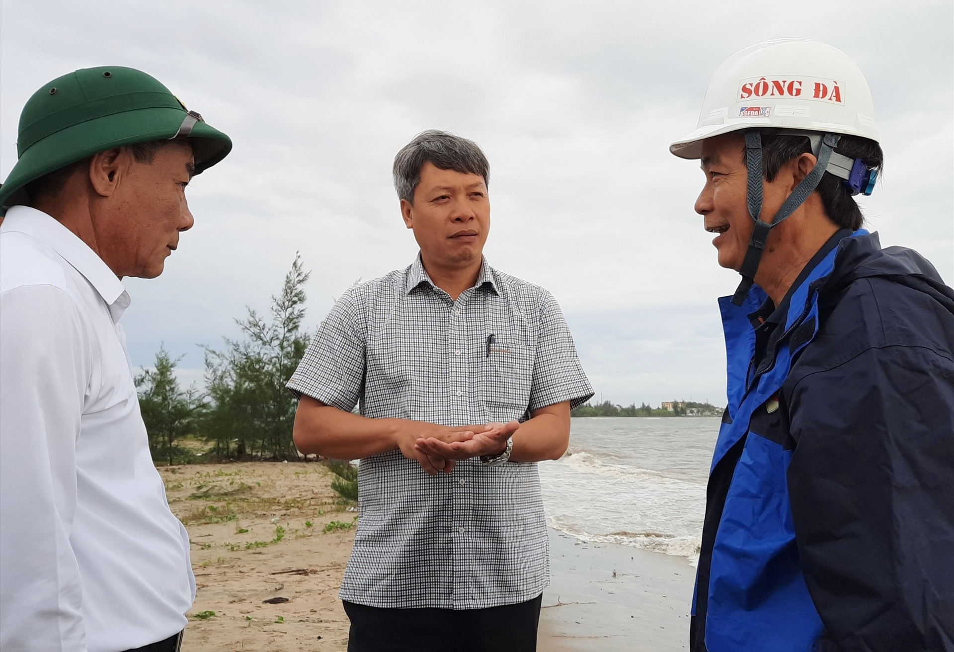 Phó Chủ tịch UBND Hồ Quang Bửu lắng nghe báo cáo của UBND huyện Duy Xuyên về tình hình sạt lở bờ biển tại xã Duy Hải. Ảnh: HỒ QUÂN