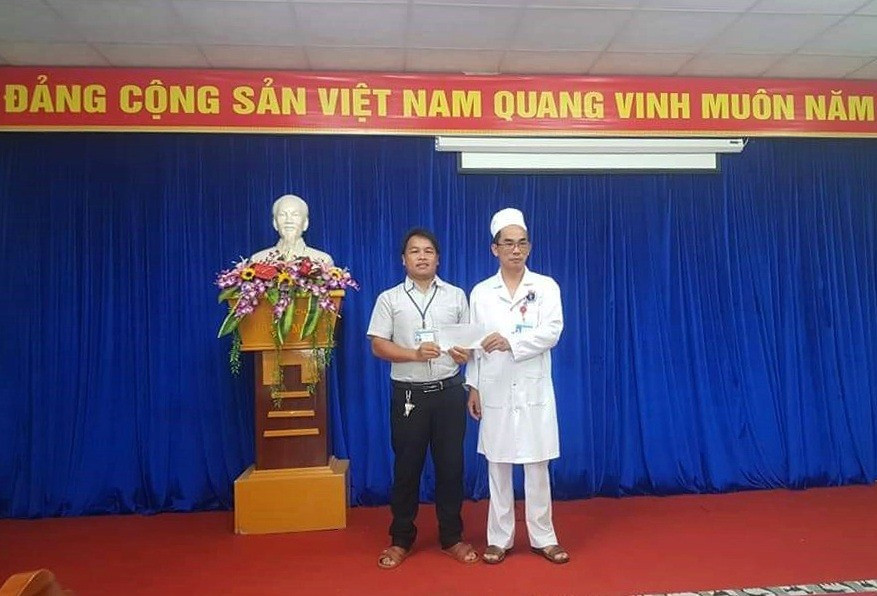 Bác sĩ Nguyễn Huy Thông (bên phải) trao quà động viên cho ông Yđêl Sơn. Ảnh: Đ.N