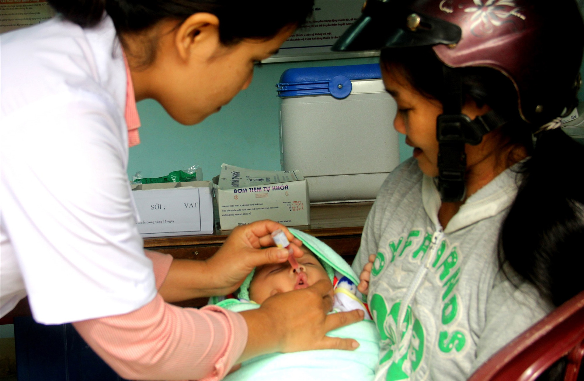 Y sĩ Trạm Y tế thị trấn Thạnh Mỹ (Nam Giang) nhỏ vắc xin cho trẻ sơ sinh. Ảnh: ĐĂNG NGUYÊN