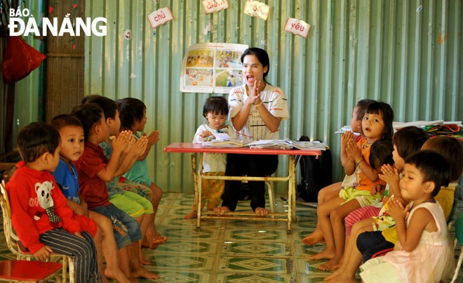 Cô giáo Hồ Thị Ca cùng con gái và các em học sinh trong một buổi học ở điểm trường Tăk Lẻ.