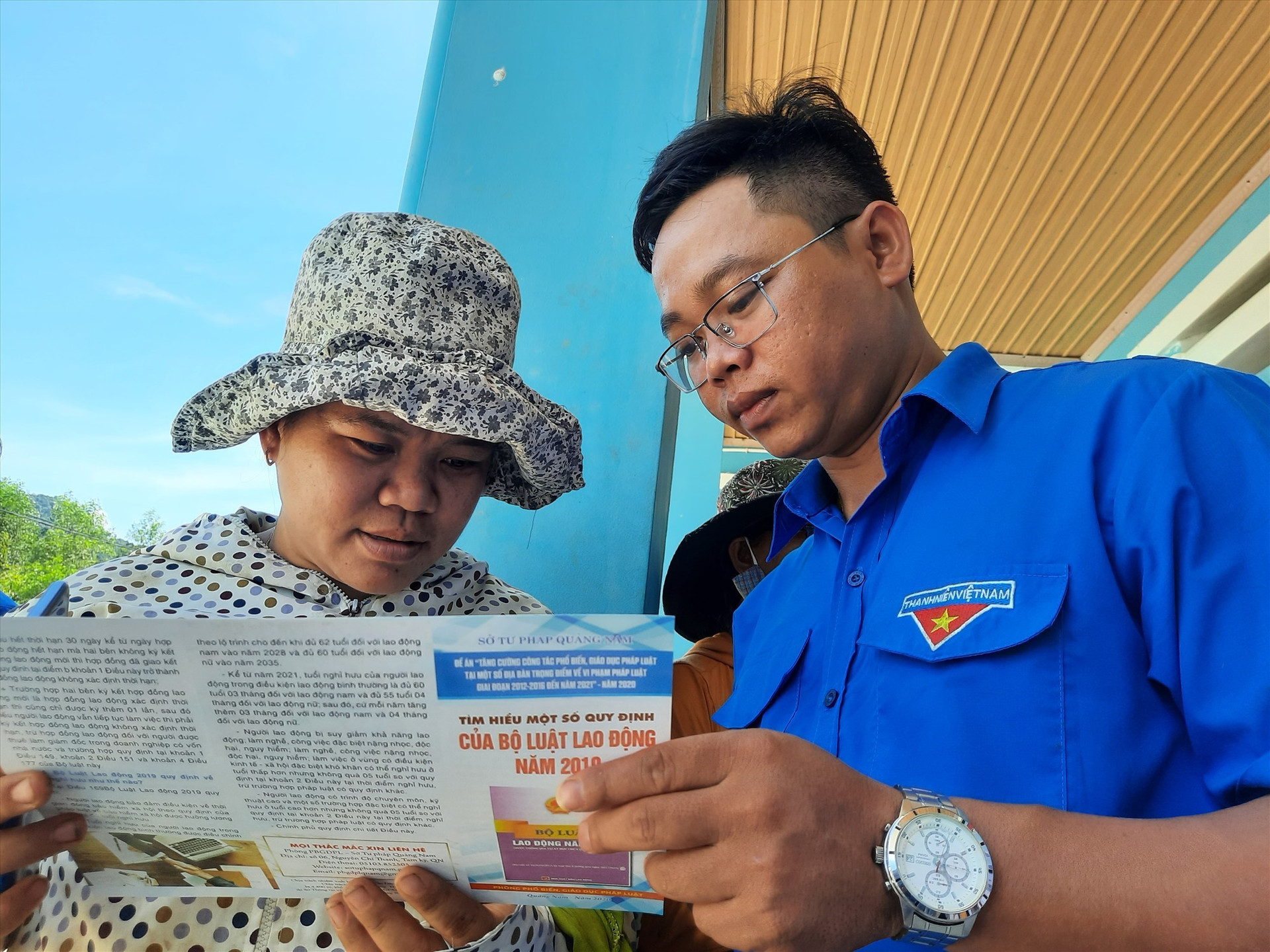 Cấp phát tờ rơi tuyên truyền các quy định mới của pháp luật Việt Nam năm 2020 cho người dân. Ảnh: HỒ QUÂN