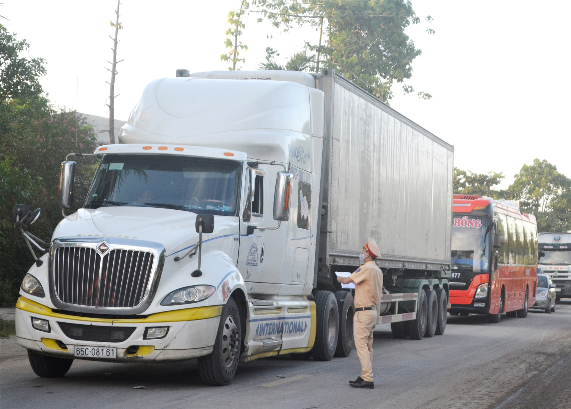 Cảnh sát giao thông tham gia chốt chặn đảm bảo ATGT, kiểm soát dịch bệnh Covid-19 trên quốc lộ 14B. Ảnh: C.T