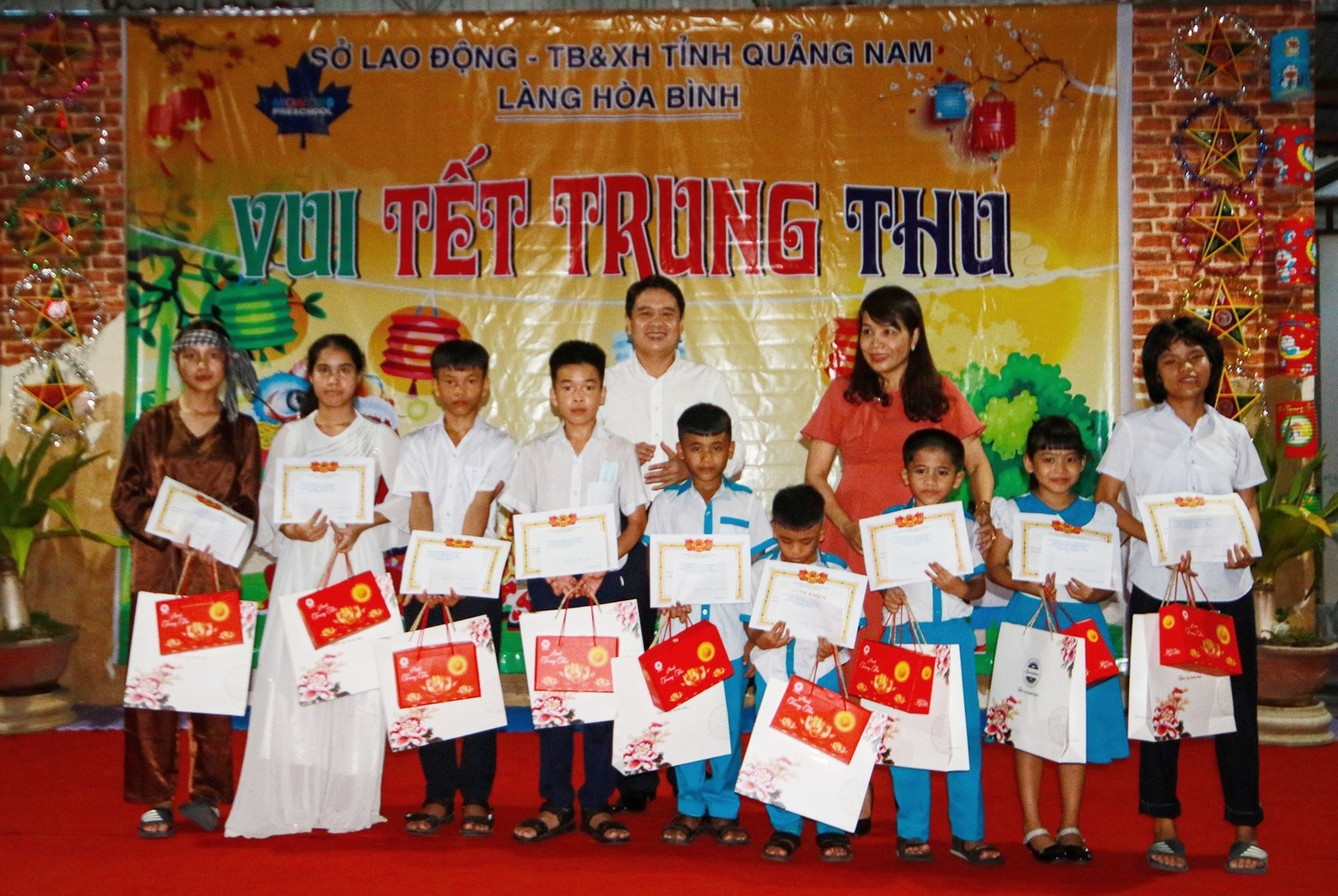 Phó Chủ tịch UBND tỉnh Trần Văn Tân và đại diện lãnh đạo Sở Lao động - Thương binh và Xã hội tỉnh tặng quà cho các em nhỏ có thành tích học tập xuất sắc. Ảnh: T.C