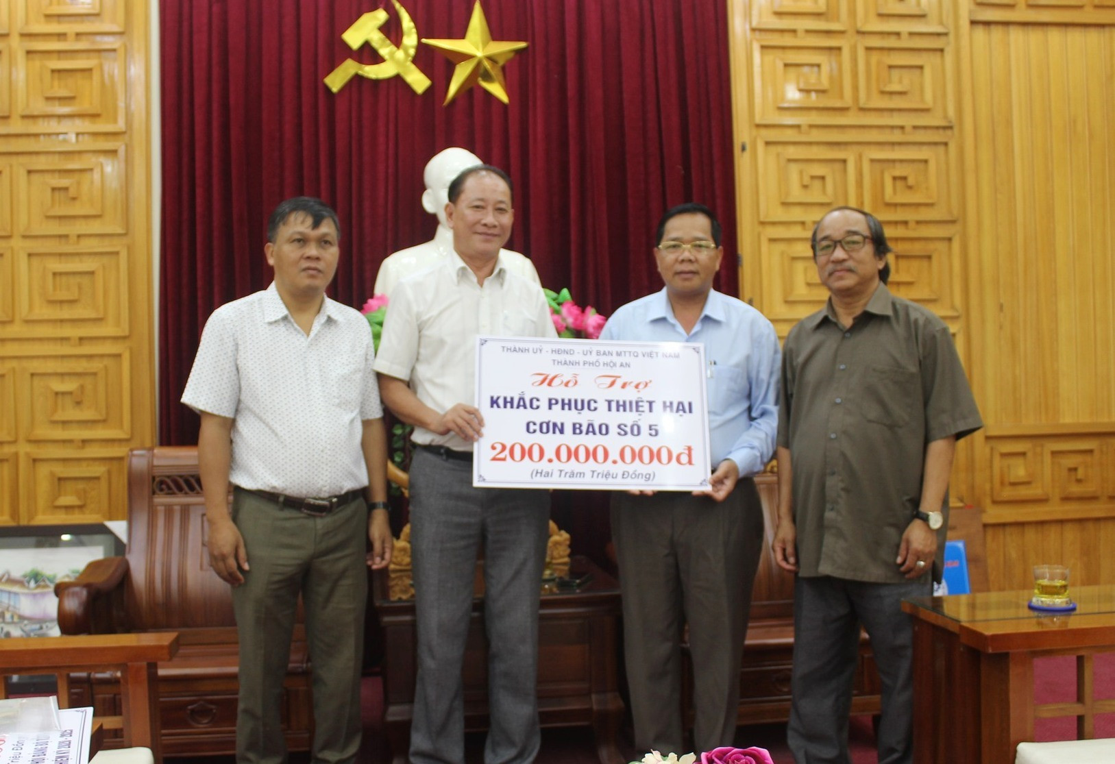 Lãnh đạo thành phố Hội An tặng bảng tượng trưng cho huyện Tây Giang, giúp Tây Giang khắc phục hậu quả cơn bão số 5