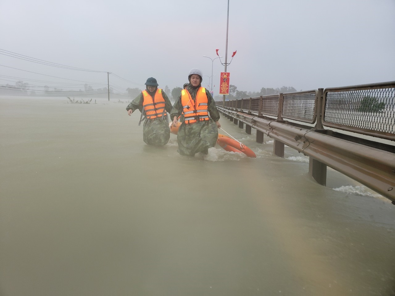 Lực lượng cứu hộ tại khu vực khu dân cư ngập lụt gần quốc lộ 1A. Ảnh: HOÀI AN