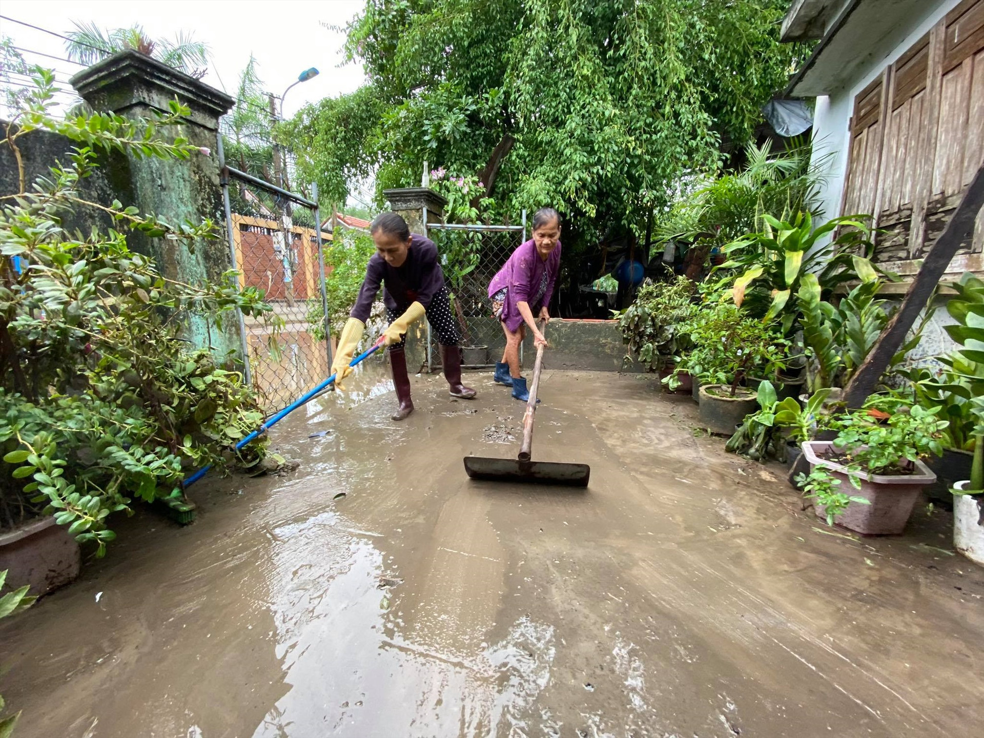 Người dân Phú Ninh dọn bùn non tràn vào nhà sau khi nước lũ rút. Ảnh: V.A