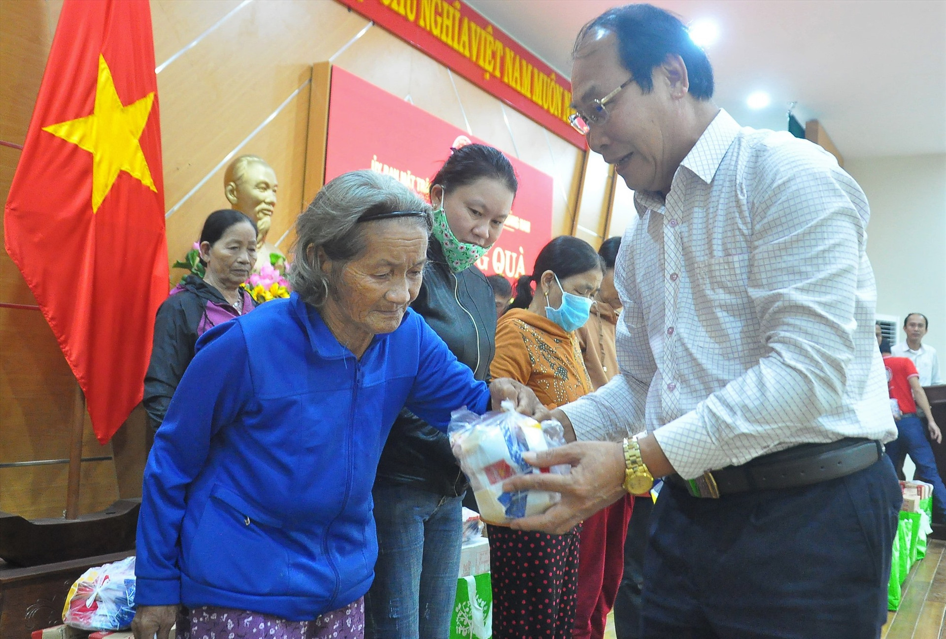 Chủ tịch Ủy ban MTTQ Việt Nam Võ Xuân Ca trao gói xúc xích trong suất quà cho một người cao tuổi của TP.Tam Kỳ. Ảnh: VINH ANH