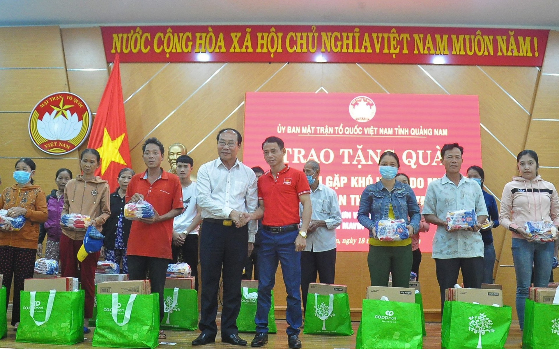 Chủ tịch Ủy ban MTTQ Việt Nam tỉnh Võ Xuân Ca cùng nhà tài trợ trao quà cho người dân vùng lũ Tam Kỳ. Ảnh: VINH ANH