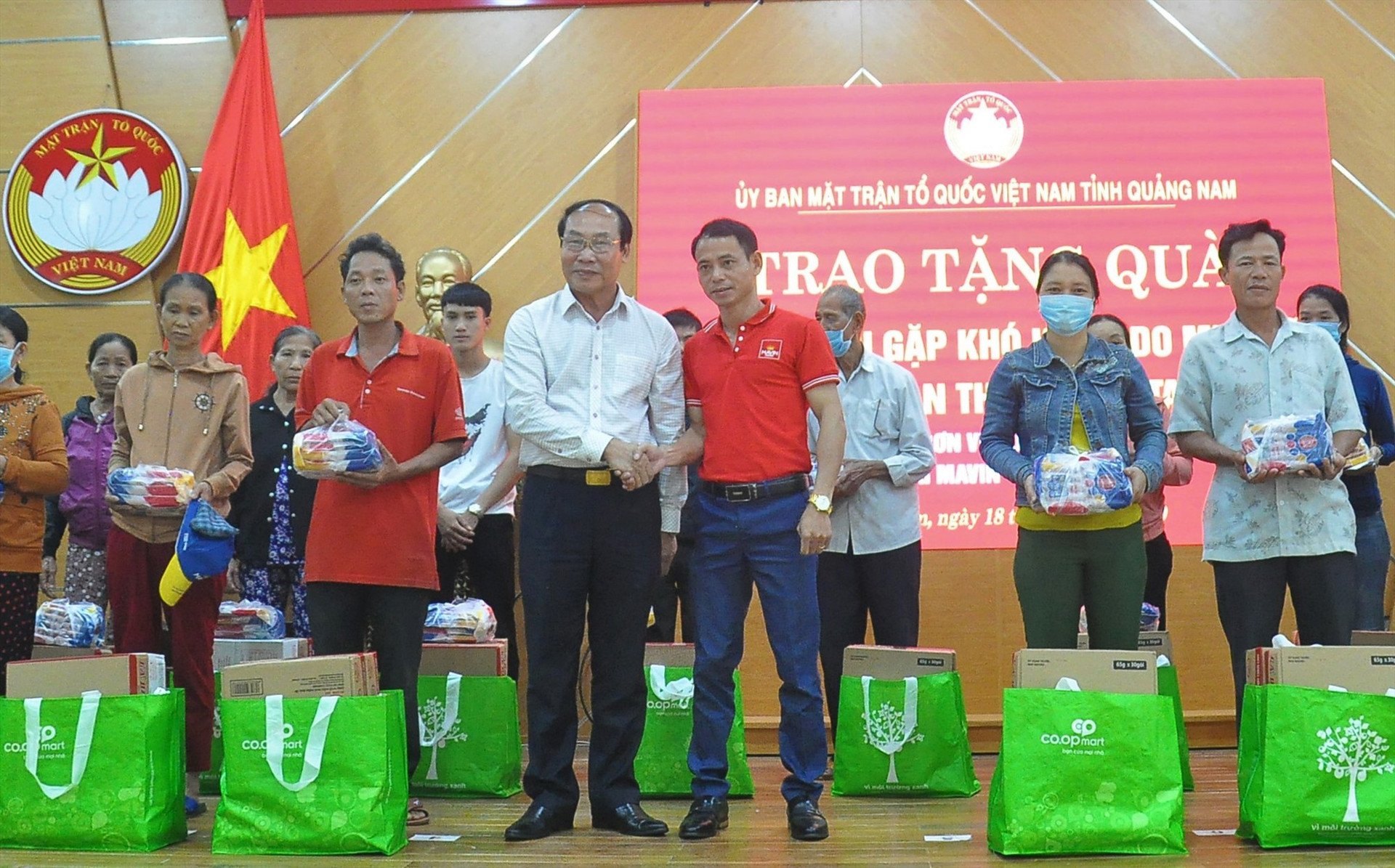 Chủ tịch Ủy ban MTTQ Việt Nam tỉnh Võ Xuân Ca cùng nhà tài trợ trao quà cho người dân vùng lũ Tam Kỳ. Ảnh: VINH ANH