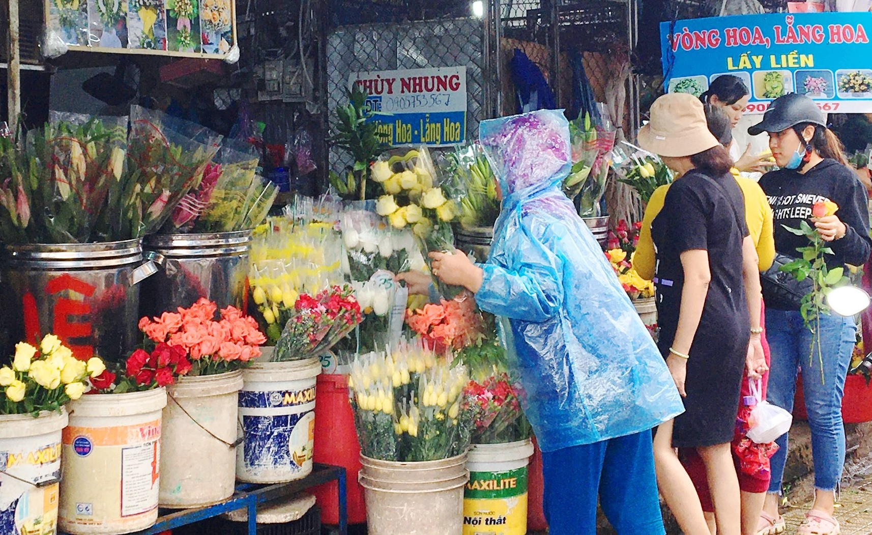 Dù trời mưa nhưng nhiều người vẫn đến mua hoa mừng ngày 20.10 tại chợ Tam Kỳ. Ảnh: KL