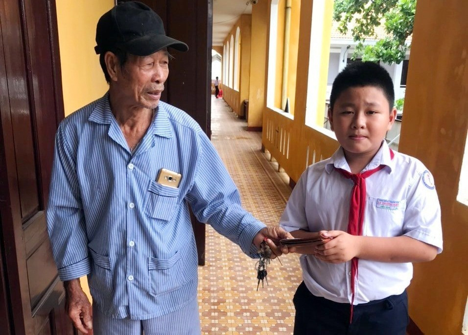 Em Võ Kiến Nghi trao lại chiếc ví cho người đánh mất.