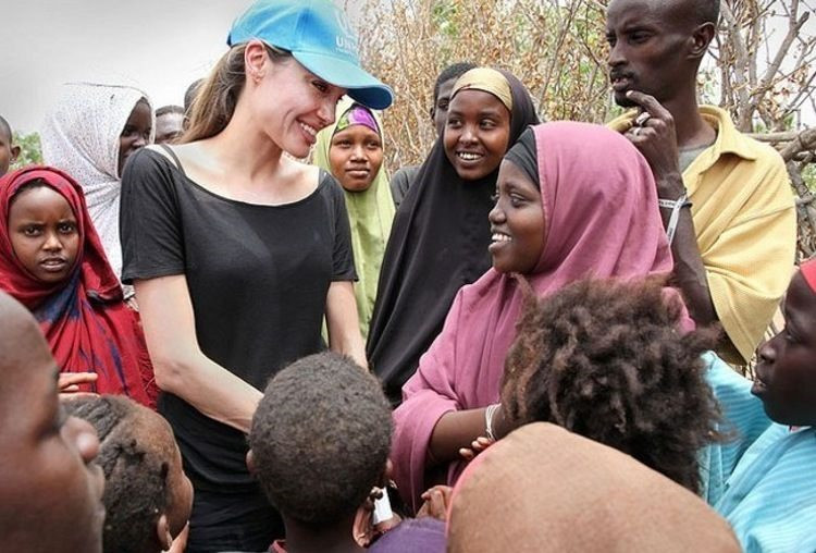 Angelina Jolie (đội mũ) trong một chuyến đi làm từ thiện. Ảnh: printerest