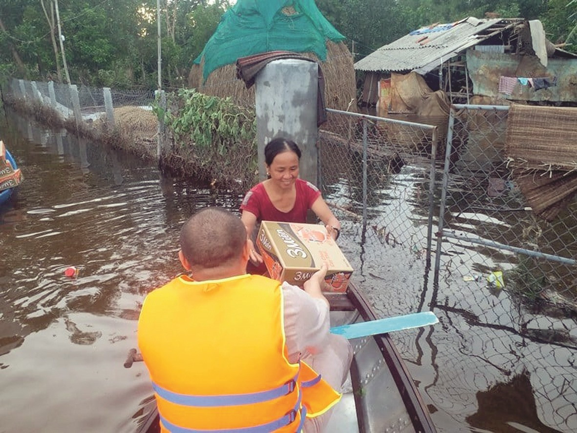 Chèo ghe đến những nơi ngập lụt để hỗ trợ mì tôm cho người dân.