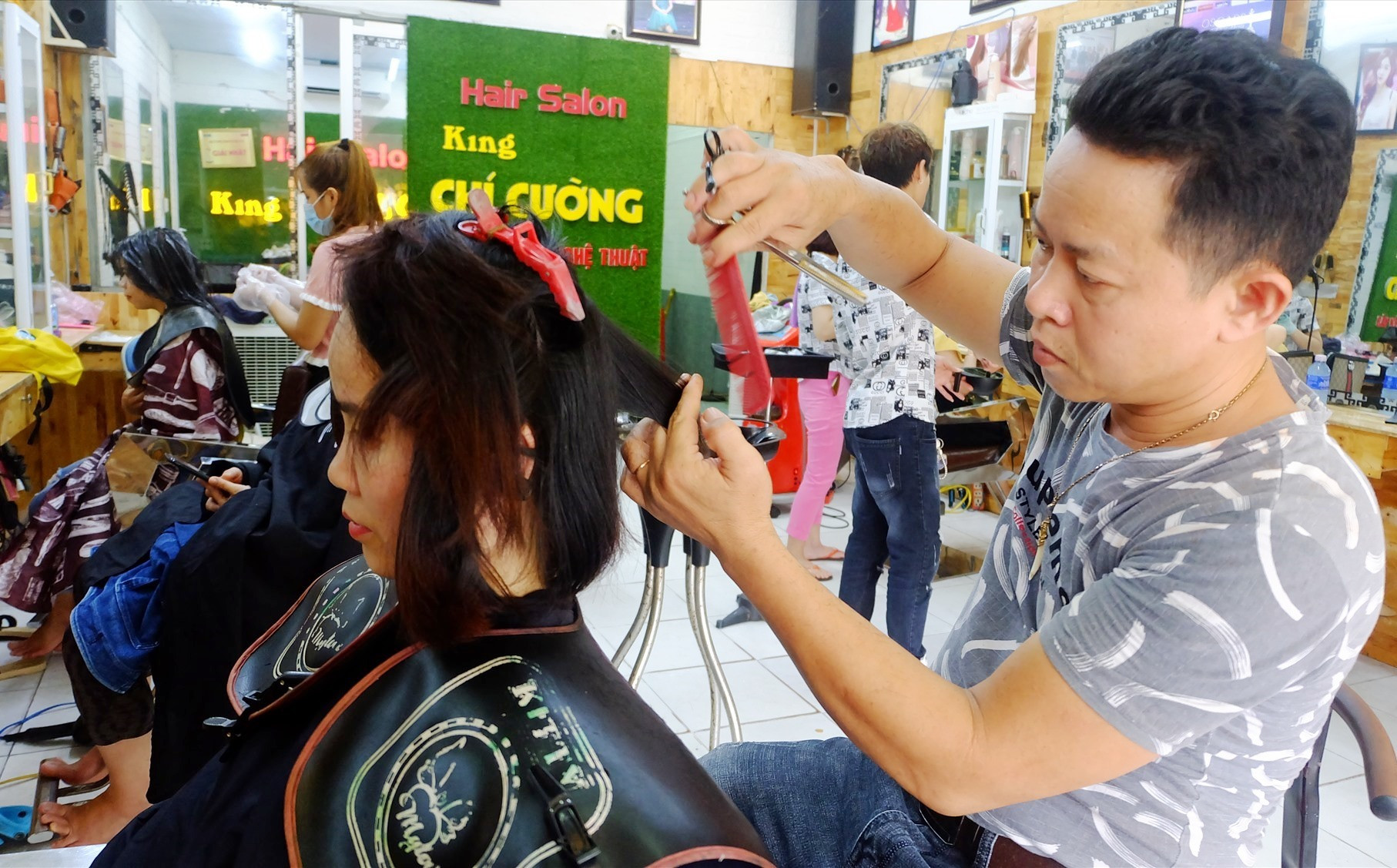 Anh Ung Nho Cường đang tạo mẫu tóc cho khách hàng. Ảnh: A.B