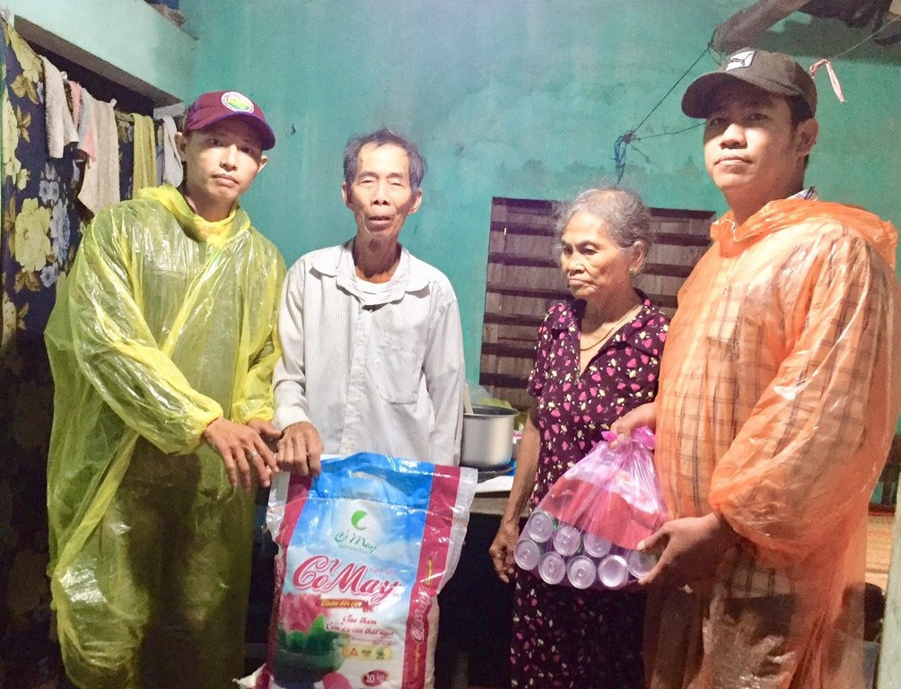Anh Châu Ngọc Nghĩa (bìa trái) tặng quà người dân Thăng Bình trong đợt bão lũ vừa qua. Ảnh: VIỆT NGUYỄN