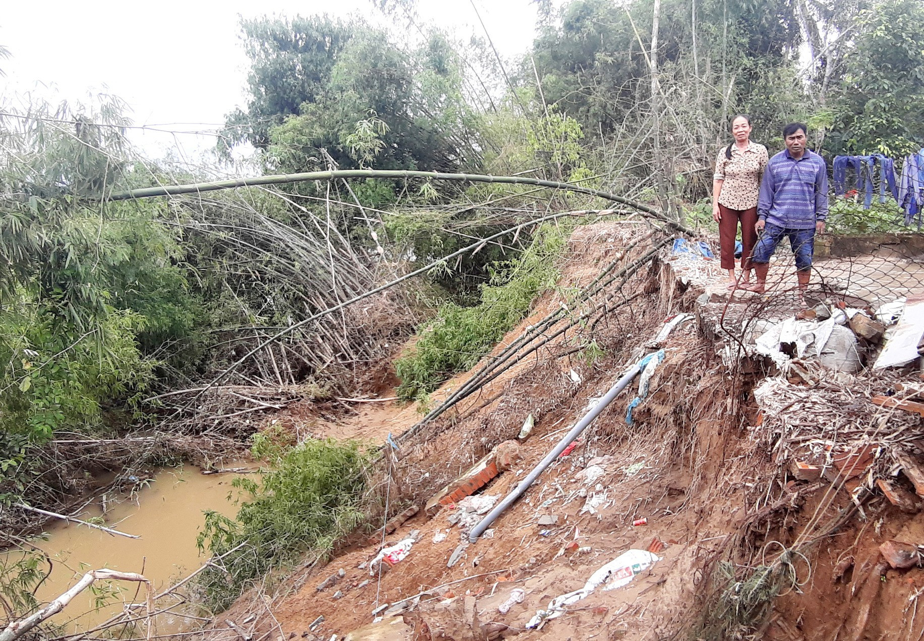 Tường rào kiên cố của vợ chồng ông Phạm Văn Tùng ở thôn Phú Đa 1 (xã Duy Thu, Duy Xuyên) đã trôi theo dòng nước. Ảnh: H.N