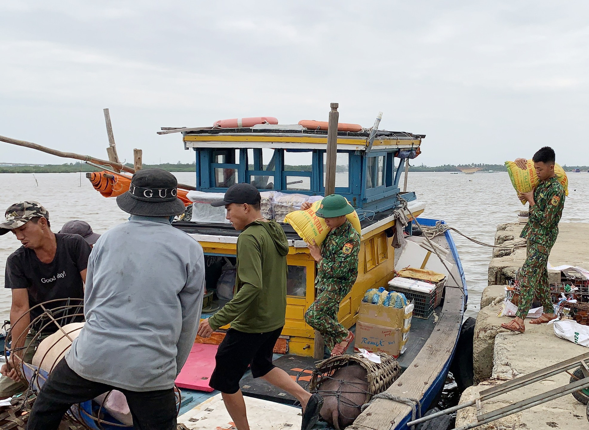 Giúp dân vận chuyển lương thực, thực phẩm ra đảo dự trữ trước bão số 9. Ảnh: T.C