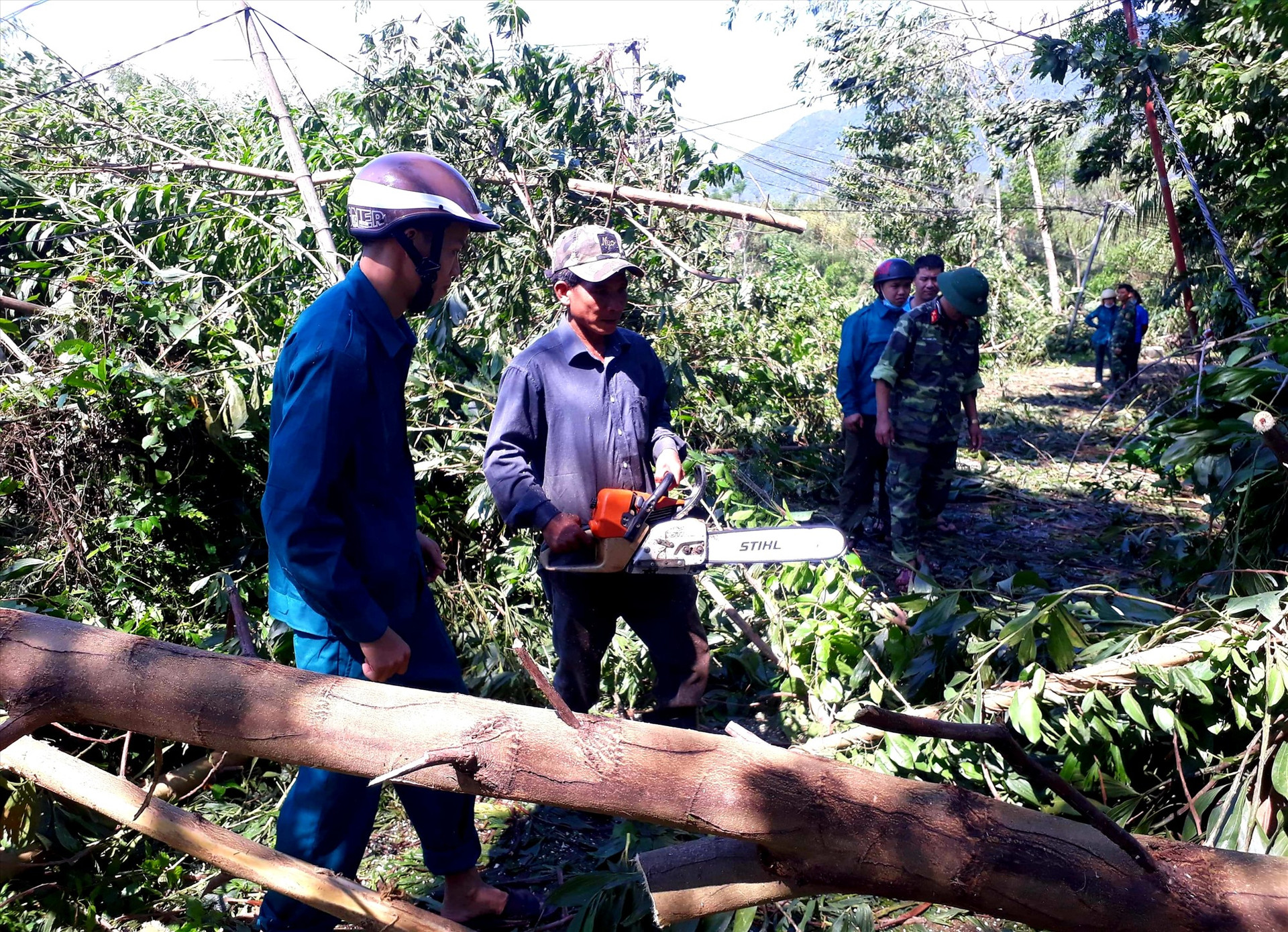 Nhiều lực lượng của huyện Quế Sơn khẩn trương xử lý cây cối ngã đổ trên các tuyến đường. Ảnh: S.T