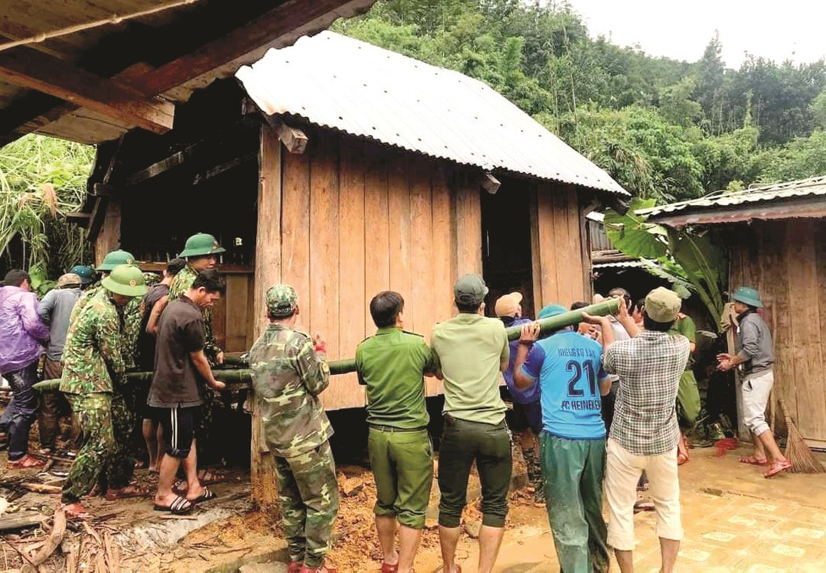 Lực lượng cứu hộ và bà con huyện Tây Giang di dời ngôi nhà khỏi vùng nguy hiểm. Ảnh: Đ.N