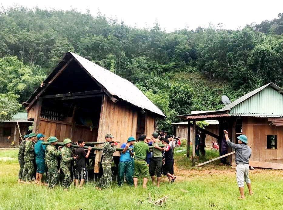 Lực lượng cứu hộ và bà con huyện Tây Giang di dời ngôi nhà khỏi vùng nguy hiểm. Ảnh: Đ.N